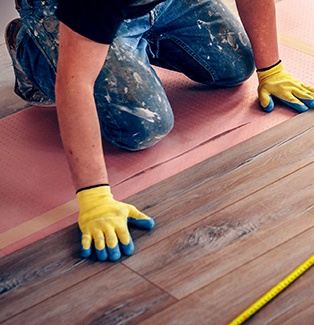 A man installing wooden floor