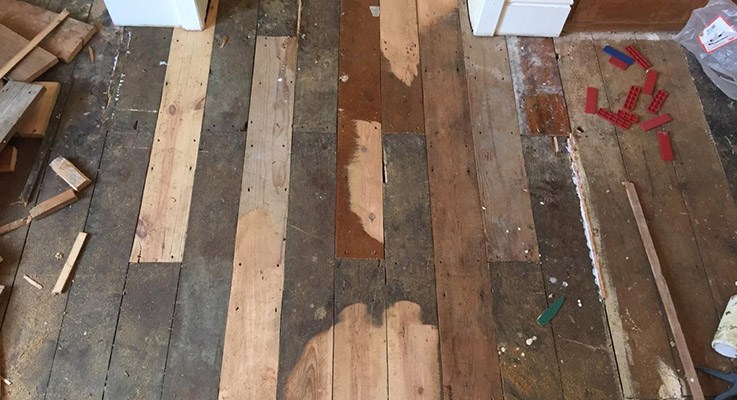 Very damaged and old wooden floor being repaired